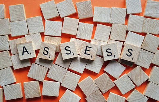 Wood blocks spelling assess on orange background